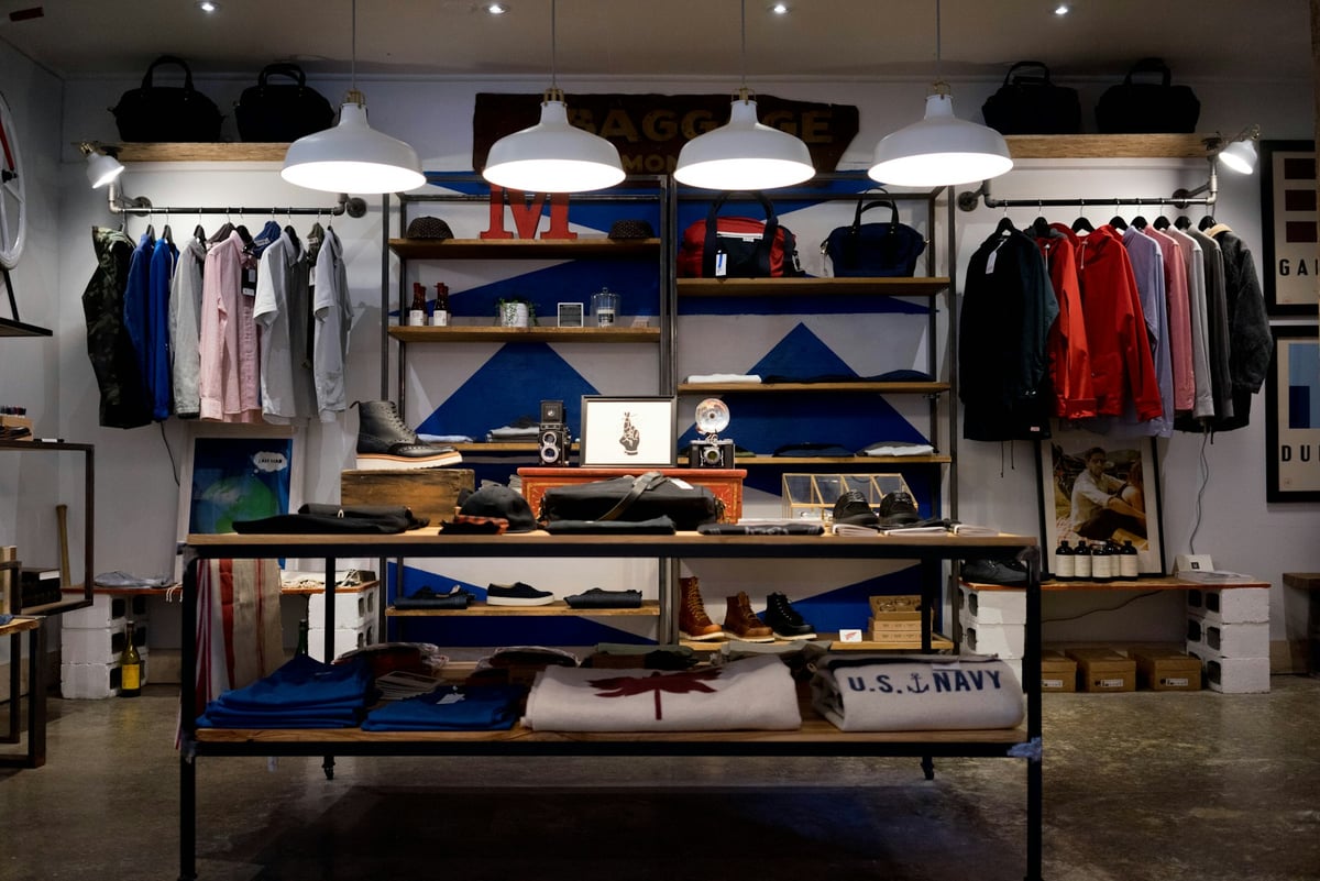 A mixed retail floor with clothes, bags, and other goods